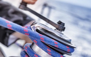 A photo of a man's hand turning crank handle on a boat.