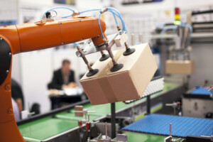 Image of packaging machine with new industrial components lifting a cardboard box.