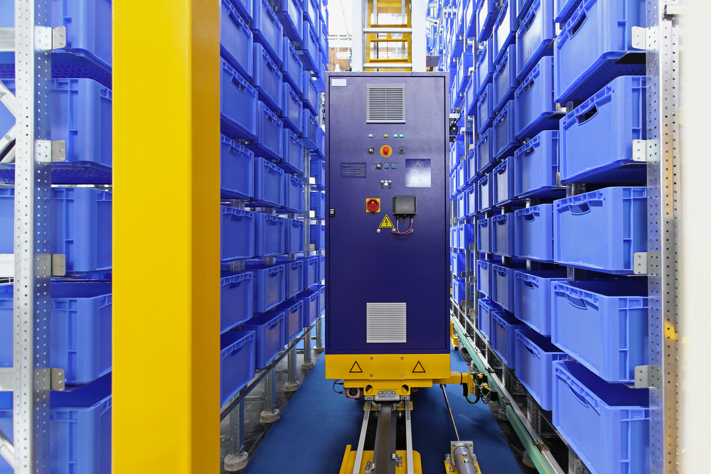 Image of Automated warehouse machine restocking blue shelf cartons.